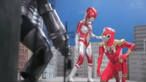 Asian Women in Racing Suits and Costumed Characters