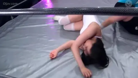 Dark-Haired Women Wrestling in Ring