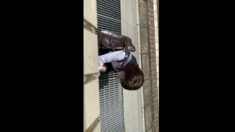 Woman Peeking Through Metal Bars
