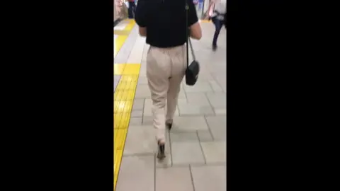 Asian Woman Walking in Public Transit