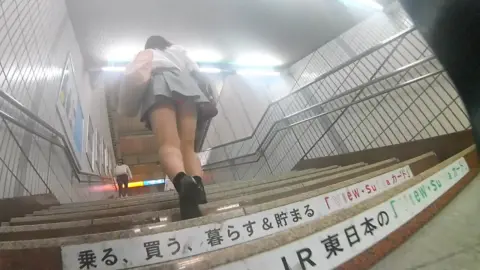 Asian teen on train stairs POV