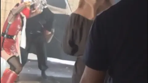 Asian woman in red costume in bondage scenes