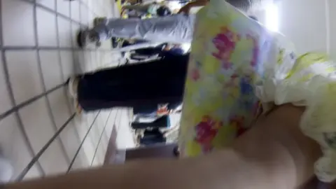 Asian in Yellow Floral Dress in Retail Store