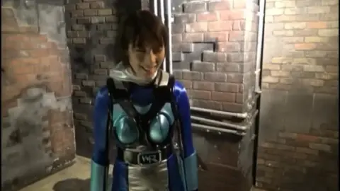 Asian Schoolgirl and Costumed Models in Industrial Setting