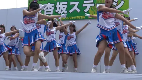 Asian Teens Dance in Uniforms on Stage