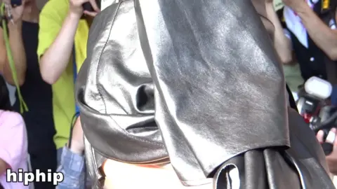 Asian Woman in Black Leather Dress at Public Event