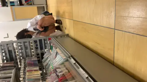 Asian Schoolgirl in Bookstore