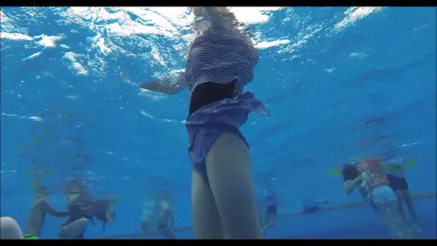 Girls in Swimwear Play at Indoor Pool