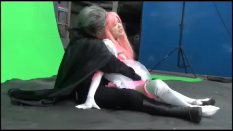 Asian Couple in Pink Dress and Black Cape Embrace
