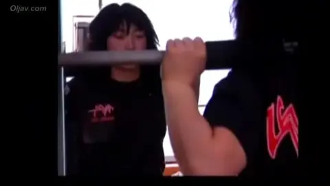 Asian Women Wrestling in Chain Link Fence Ring