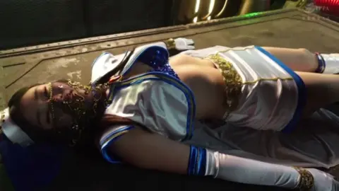 Asian Model in Blue Costume Performs