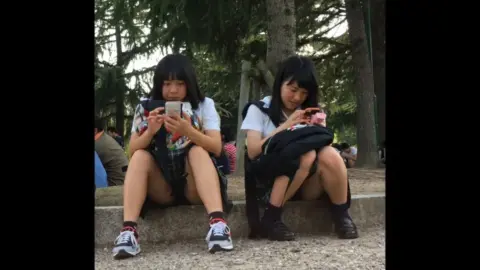 Asian Schoolgirls in Uniform Flirt on Steps