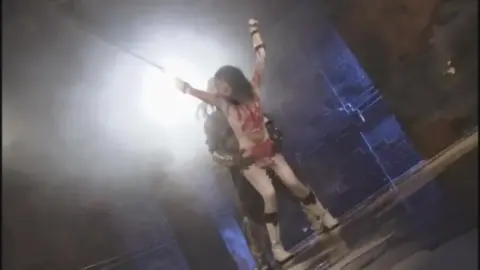 Asian woman in bloody outfit restrained and manipulated
