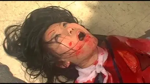 Asian in Red Costume Restrained and Bloodied
