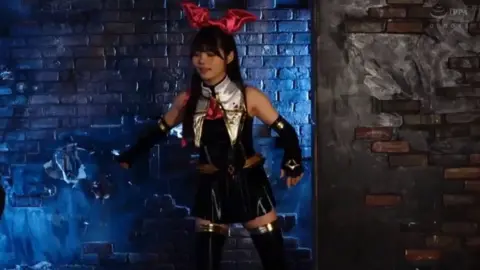 Asian Brunette with Red Bow Posing with Spear