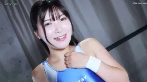 Asian Wrestlers Grappling on Mats