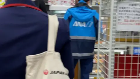 Asian in Blue Uniform with ‘JAPAN’ Tote Bag