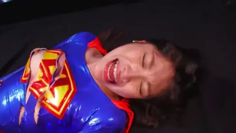 Asian Girl in Superman Costume Industrial Fetish Scene