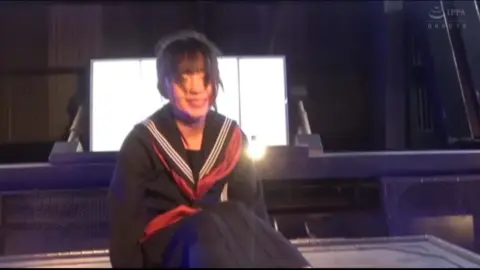 Asian Performers in Intimate Embrace on Stage