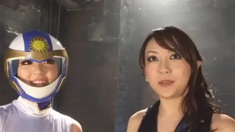 Asian Duo in Costume Posing in Dark Room