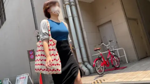 Asian Girl in Blue Top and Black Skirt on Street