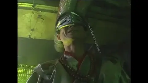 Dark Haired Woman in Gold Bikini Bondage Scene