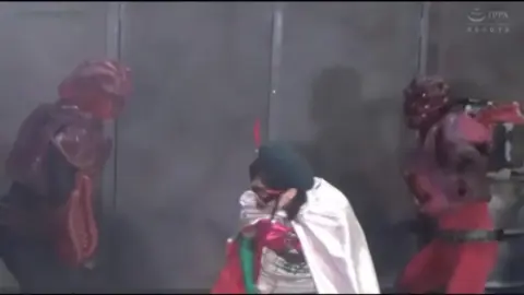 Asian Performer in Mask and Cape