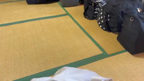 Asian woman in white gloves on tatami mat