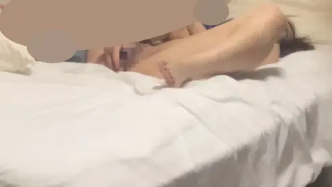 Asian Teen Lies on Bed with Legs Raised