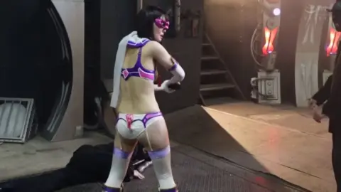 Asian Performer in Futuristic Costume and Mask