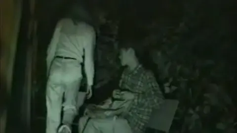 Couple Embracing in Garden at Night