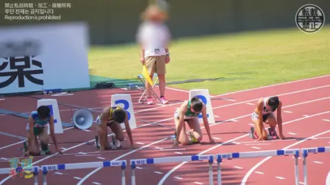 Asian Athletes in Sports Uniforms Hurdle Racing